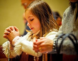 Anna Maria Krupka and her mother, Mary Miceli-Krupka, only partially visible, pray the rosary at Saint Francis Seminary, St. Francis, during the 10th anniversary celebration of the Rosary Evangelization Apostolate on Tuesday, Feb. 19. (Catholic Herald photo by Juan C. Medina)