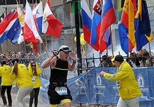 A runner and race officials at the finish line of the Boston Marathon react to an explosion April 15. Two bombs exploded in the crowded streets near the finish line of the marathon, killing at least three people, including an 8-year-old boy, and injuring more than 140. (CNS photo/MetroWest Daily News/Ken McGagh, handout via Reuters) 