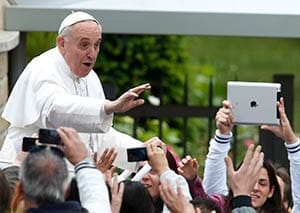 Pope Francis greets people after celebrating Mass at Sts. Elizabeth and Zechariah Parish on the outskirts of Rome May 26. The pope gave first Communion to 16 children at the parish. (CNS photo/Paul Haring)