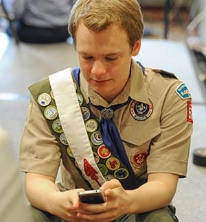 Pascal Tessier, 16, from Kensington, Md., who was facing expulsion from the Boy Scouts because he is gay, sends out a text message on his phone after a resolution to allow openly gay Scouts in the Boy Scouts of America was passed May 23. The vote came during the organization's annual meeting being held in the Dallas suburb of Grapevine, Texas. (CNS photo/Michael Prengler, Reuters)