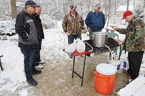 Members of the Holy Brewers, Mark Staral, left to right, Dan Karasch, Bryon Baker, Tim Logman and Pete Weingarten, brew beer Saturday, April 2 in Weingarten’s backyard. (Catholic Herald photo by Ricardo Torres)