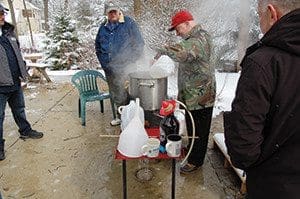 as Tim Logman looks on, Weingarten adds ingredients as part of the cooking process. (Catholic Herald photos by Ricardo Torres)