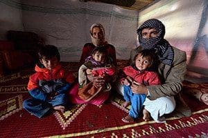 A refugee family from Syria poses for a photo in 2012 in their tent in Lebanon. Pope Francis' postsynodal apostolic exhortation on the family, "Amoris Laetitia" ("The Joy of Love"), was to be released April 8. The exhortation is the concluding document of the 2014 and 2015 synods of bishops on the family. (CNS photo/Paul Jeffrey)