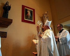  Archbishop Jerome E. Listecki blesses a new Divine Mercy worship area at St. Anne Parish, Pleasant Prairie, on Sunday, April 3. The area includes a large print of Divine Mercy and Italian-crafted statues of St. Faustina and St. John Paul II. At left, the statue of St. John Paul II is readied for installation. (Submitted photo at left; above Catholic Herald photo by Allen Fredrickson)