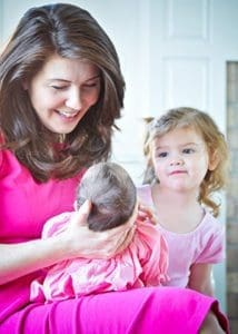 Michelle Cascio holds her 6-week-old daughter Ciara Marie as 3-year-old Clare looks on in this photo taken at the family’s Menomonee Falls home on Monday, May 2. (Catholic Herald photo by Juan C. Medina)