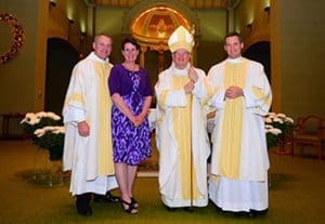 Bishop David L Ricken of Green Bay, Wis., is pictured with Deacon David Parker Sr., left, his wife, Denise, and their son David Jr., following the father and son's ordination as deacons May 7 at Assumption of the Blessed Virgin Mary Church in Pulaski, Wis. The younger Parker, a member of the Legionaries of Christ, was ordained a transitional deacon and and will be ordained to the priesthood in December. (CNS photo/Sam Lucero, the Compass)