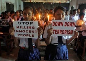 School children in Agartala, India, hold candles and placards as they pray during a June 29 vigil to show solidarity with the victims of the suicide attack at Istanbul's Ataturk Airport. The June 28 bombings killed dozens and wounded more than 200 as Turkish officials blamed the carnage at the international terminal on three suspected Islamic State group militants. (CNS photo/Jayanta Dey, Reuters)