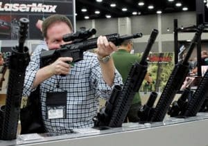 A man looks through a rifle scope in late May at the National Rifle Association's Annual Meetings & Exhibits show in Louisville, Ky. In the first 180 days of 2016, there have been 163 mass shootings in the United States, according to data gathered by the Washington-based nonprofit Gun Violence Archive. (CNS photo/John Sommers II, Reuters)