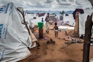 Refugees walk outside their tents in early February in the Kapise refugee camp in Mwanza, Malawi. Catholic officials who work with refugees in Malawi said they have warned albinos against going to certain areas of such camps because crimes against albinos are on the rise. (CNS photo/Erico Waga, EPA)