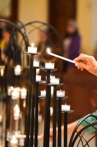 A participant of the "Vigil to Dry Tears" lights a candle June 13 at St. James Cathedral in Orlando, Fla., for victims of a mass shooting at Pulse nightclub in Orlando. The event gathered interfaith leaders and some 500 people from all walks of life for prayer, music, scripture and reflection. (CNS photo/Andrea Navarro, Florida Catholic)