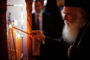 Orthodox Archbishop Ieronymos II of Athens and all of Greece lights a candle as he enters St. Mena Cathedral in Heraklion, Greece, June 19. The Great and Holy Council of the Orthodox Church opened June 19. Although intended to be the first council of all the Orthodox churches in more than a millennium, the gathering opened with the absence of representatives from four Orthodox churches. (CNS photo/Sean Hawkey, handout)