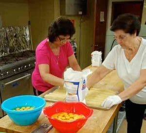 Some of the 150 volunteers at Our Lady of Mount Carmel, Kenosha, prepare food on Tuesday, June 21 for the parish's pasta dinner to be served July 8 and 9. (Catholic Herald photo by Ricardo Torres) 