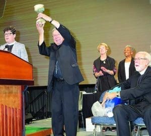 Baltimore Auxiliary Bishop Denis J. Madden holds up a chalice Aug. 10 that he received from Presiding Bishop Elizabeth Eaton of the Evangelical Lutheran Church in America, left, during the ELCA Churchwide Assembly in New Orleans. (CNS photo/Christine Bordelon, Clarion Herald)