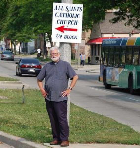 Fr. Robert Stiefvater, pastor of All Saints Church, Milwaukee, stands in the neighborhood where the parish is located in this file photo. All Saints has been chosen to host (Catholci