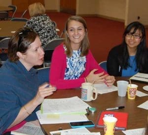 Terisa Folaron, left to right, Mary Margaret Adams and Eizabeth Aviles, incoming teachers for Seton Catholic Schools, share classroom experiences during a first-year orientation at the Cousins Center, Monday, Aug. 15. (Catholic Herald photo by Joe Poirier)