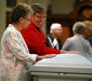 Mourners pray before the casket holding School Sister of St. Francis Margaret Held, Sept. 2, at the St. Joseph Center, Milwaukee. Sr. Margaret and Sister of Charity of Nazareth Paula Merrill were murdered a week earlier in their home in Mississippi. Mourners listen as Archbishop Jerome E. Listecki delivers the homily at the funeral Mass for Sr. Margaret in the chapel at the St. Joseph Center in Milwaukee, Sept. 2. (Catholic Herald photos by Allen Fredrickson) 