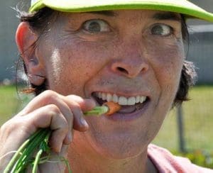 Connie Holzmiller samples a carrot from the Garden of Eat’n at St. Joan of Arc Parish, Nashotah, Aug. 24. (Catholic Herald photo by John Kimpel)