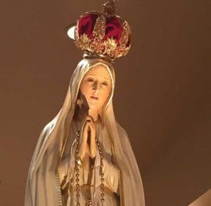 The traveling pilgrimage statue of Our Lady of Fatima is illumined Aug. 21 at St. Paul Church in Sellersburg, Indiana. The statue, a duplicate of the one at the shrine of Our Lady of Fatima in Portugal, was commissioned in 1947 to travel the world, sharing the message of Our Lady of Fatima, who appeared six times to three shepherd children in 1917. (CNS photo/Natalie Hoefer, The Criterion )