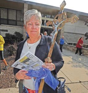 A woman, carrying an artifact from Lumen Christi Thiensville, exits the church following a closing Mass on Sunday, Sept. 24. After Mass, a ceremonial “closing of the doors” was held and religious artifacts from the Thiensville church were moved to the Mequon church in a car procession. (Catholic Herald photos by Sam Arendt)