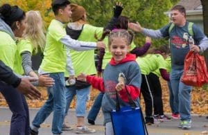 Gabrielle-Nyemeck-(St.-Mathias-School)-gives-high-fives-at-halfway-point. (Catholic Herald photo by Peter Fenelon)