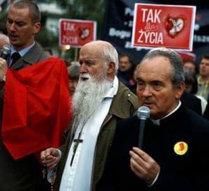 A clergyman and others pray as they take part in Sept. 22 pro-life rally in front of the parliament in Warsaw, Poland. Banners read: “Yes for life.” (CNS photyo/Kacper Pempel, Reuters)