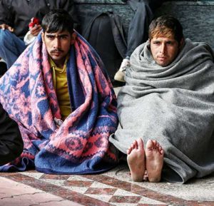 Refugees and migrants on their way to the Hungarian border warm themselves at a gas station in Indija, Serbia, Oct. 5. Pope Francis called Christians who reject refugees, “hypocrites.” (CNS photo/Marko Djurica, Reuters)