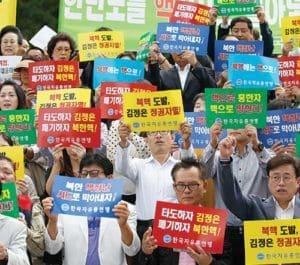 South Korean activists shout slogans as they hold up banners reading “Overthrow North Korean leader Kim Jong-un,” during a Sept 12 protest in Seoul against North Korea’s fifth nuclear test. (CNS photo/Jeon Heon-Kyun, EPA)