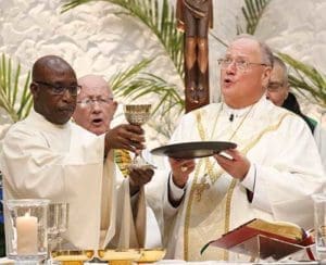 New York Cardinal Timothy M. Dolan, right, and Deacon James Francis elevate the Eucharist during a Mass marking the close of the centennial year of the Franciscan Handmaids of the Most Pure Heart of Mary Oct. 8 at St. Charles Borromeo Church in the Harlem section of New York City. (CNS photo/Gregory A. Shemitz)