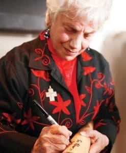 Sr. Toni Ann Palermo, a member of the School Sisters of St. Francis, signs a baseball bat during an event hosted by the Interfaith Conference of Greater Milwaukee, on Thursday, Oct. 27 at Miller Park. (Catholic Herald photo by Allen Fredrickson)