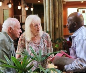 Sister of St. Francis of Assisi Edna Lonergan speaks to entrepreneur Larry Adams, right, and an unidentified potential investor, left, during the business incubator workshop.