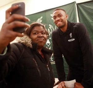 Rose Maclin takes a selfie with Milwaukee Bucks’ player Jabari Parker during his Nov. 22 visit to the House of Peace. (Catholic Herald photos by Allen Fredrickson)