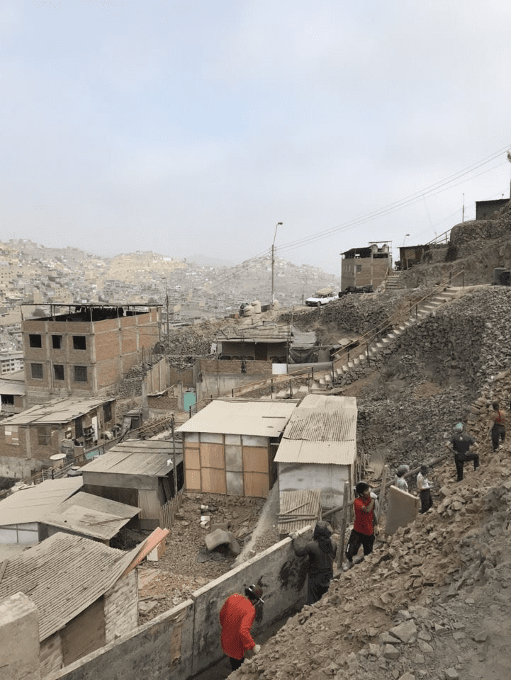 Men working to build a concrete wall.